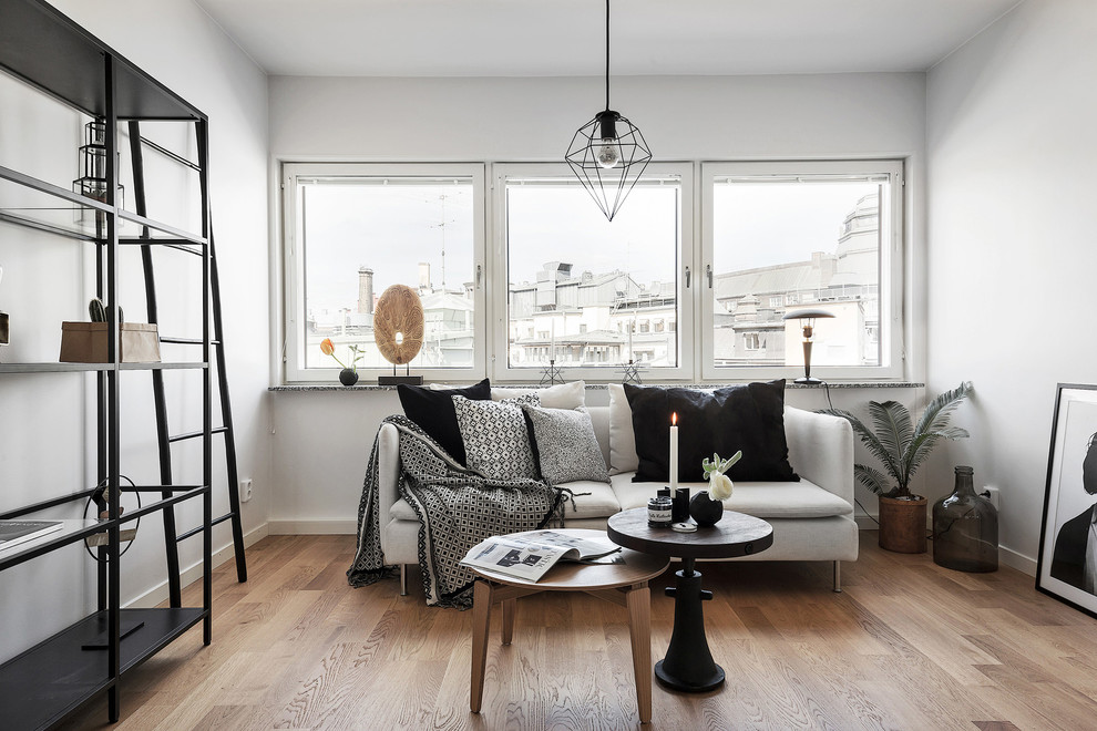 Inspiration för små minimalistiska separata vardagsrum, med vita väggar, ljust trägolv och ett finrum