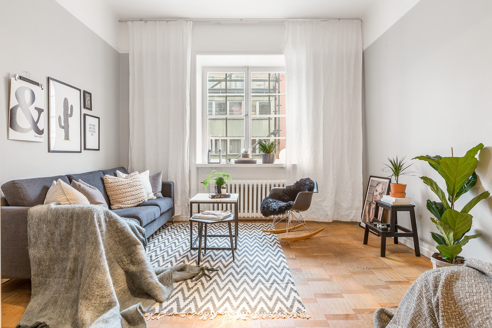 Medium sized scandinavian formal enclosed living room in Stockholm with grey walls and medium hardwood flooring.