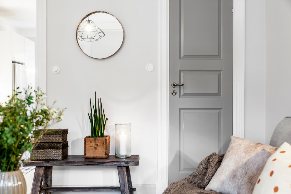 Foto på ett mellanstort skandinaviskt separat vardagsrum, med vita väggar, målat trägolv, en dold TV och vitt golv