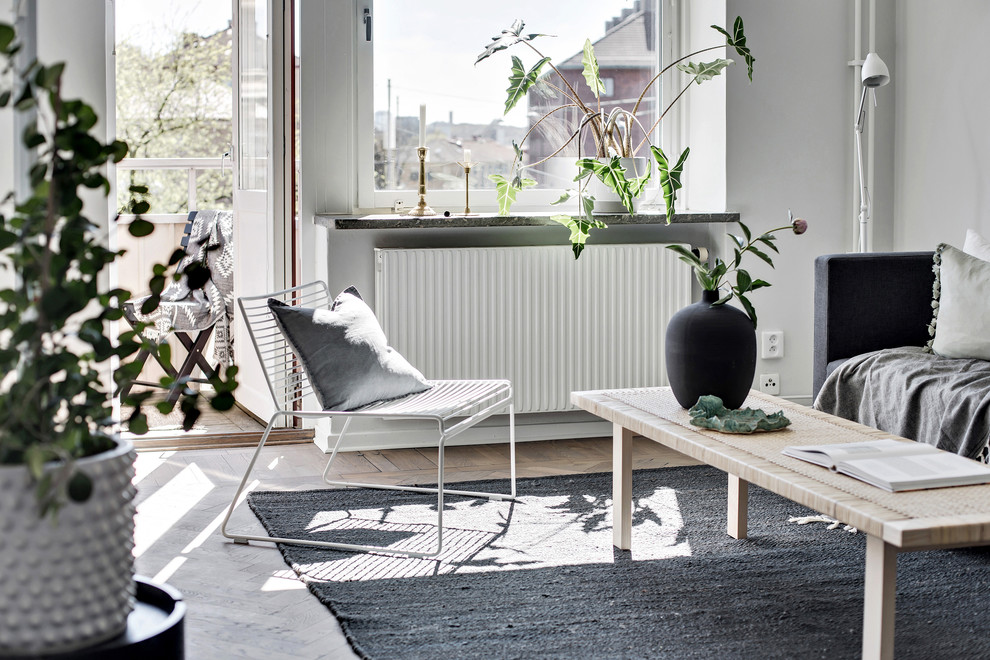Nordisk inredning av ett vardagsrum, med grå väggar, mörkt trägolv och brunt golv