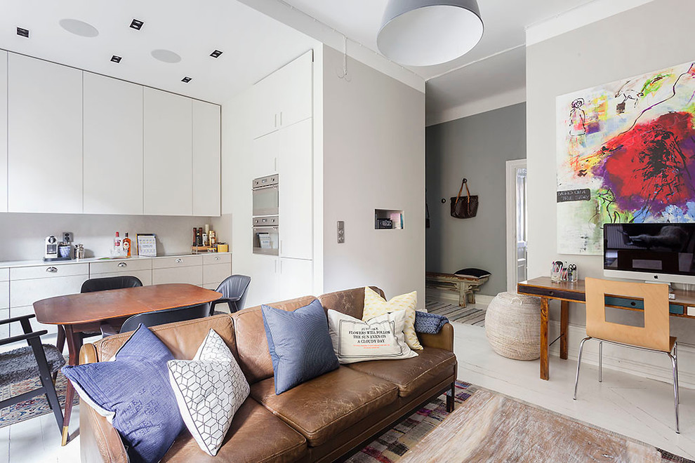 На фото: маленькая открытая, парадная гостиная комната в современном стиле с серыми стенами, деревянным полом, телевизором на стене и коричневым диваном без камина для на участке и в саду с
