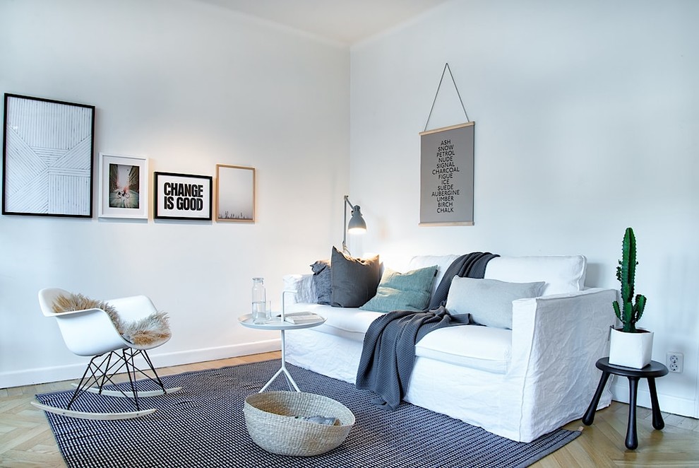 Imagen de salón para visitas cerrado escandinavo de tamaño medio sin chimenea y televisor con paredes grises y suelo de madera clara