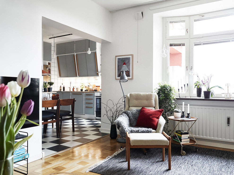 На фото: открытая гостиная комната среднего размера в скандинавском стиле с светлым паркетным полом и белыми стенами без камина, телевизора