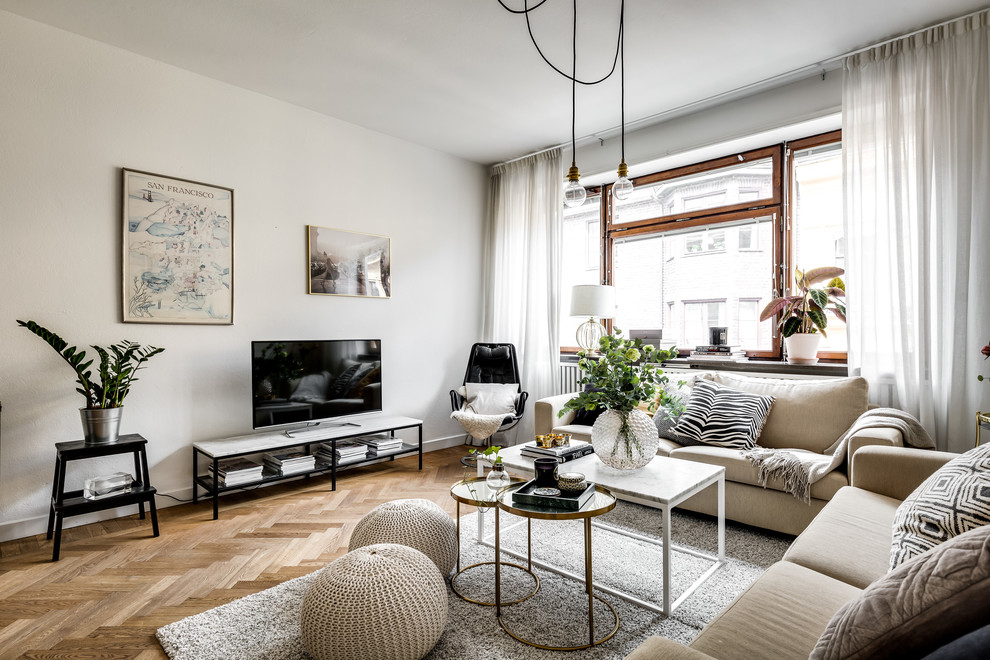 Bild på ett skandinaviskt vardagsrum, med ett finrum, vita väggar, mellanmörkt trägolv, en fristående TV och brunt golv
