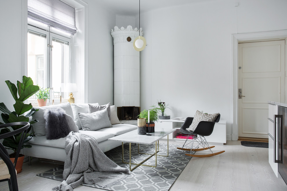 Inspiration för minimalistiska separata vardagsrum, med vita väggar, laminatgolv, en öppen vedspis, en spiselkrans i metall och grått golv