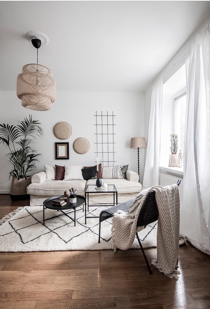 Scandinavian living room in Stockholm with white walls and dark hardwood flooring.