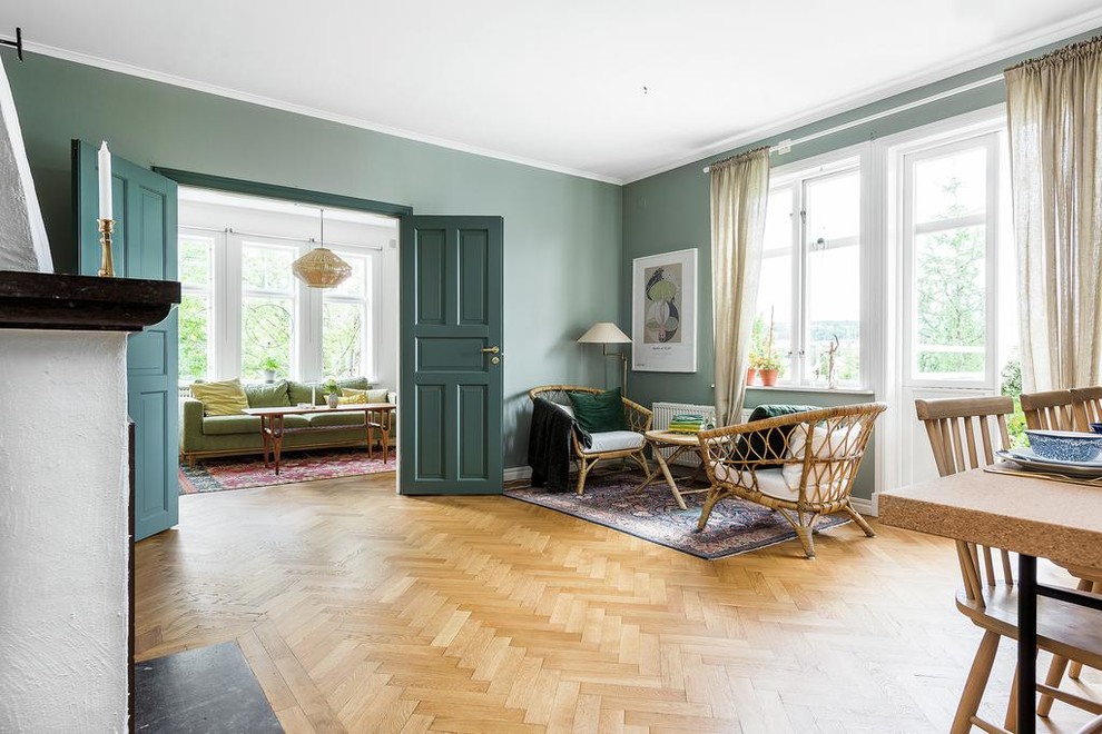 Inredning av ett minimalistiskt mellanstort separat vardagsrum, med ett finrum, gröna väggar och mellanmörkt trägolv