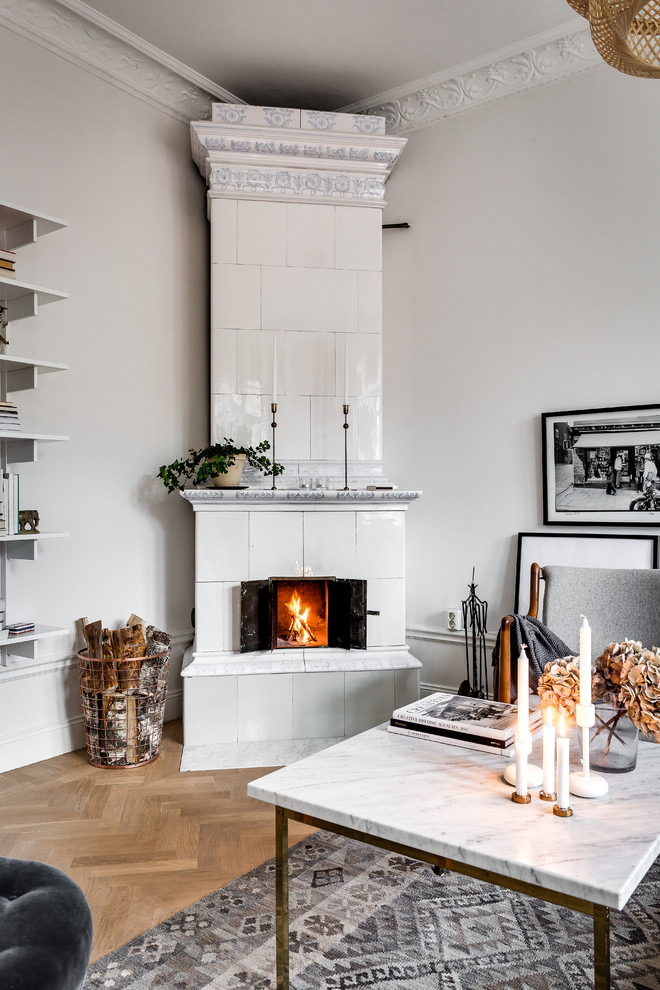 Photo of a medium sized victorian living room in Stockholm with white walls, medium hardwood flooring, a corner fireplace and a freestanding tv.