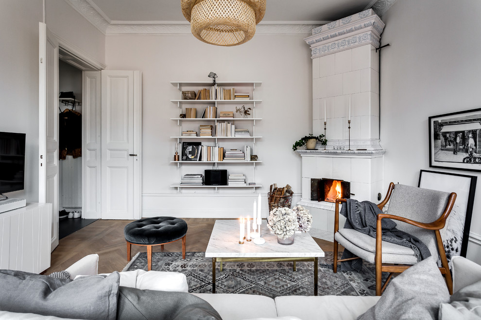 Idee per un soggiorno vittoriano di medie dimensioni con pareti bianche, pavimento in legno massello medio, camino ad angolo e TV autoportante