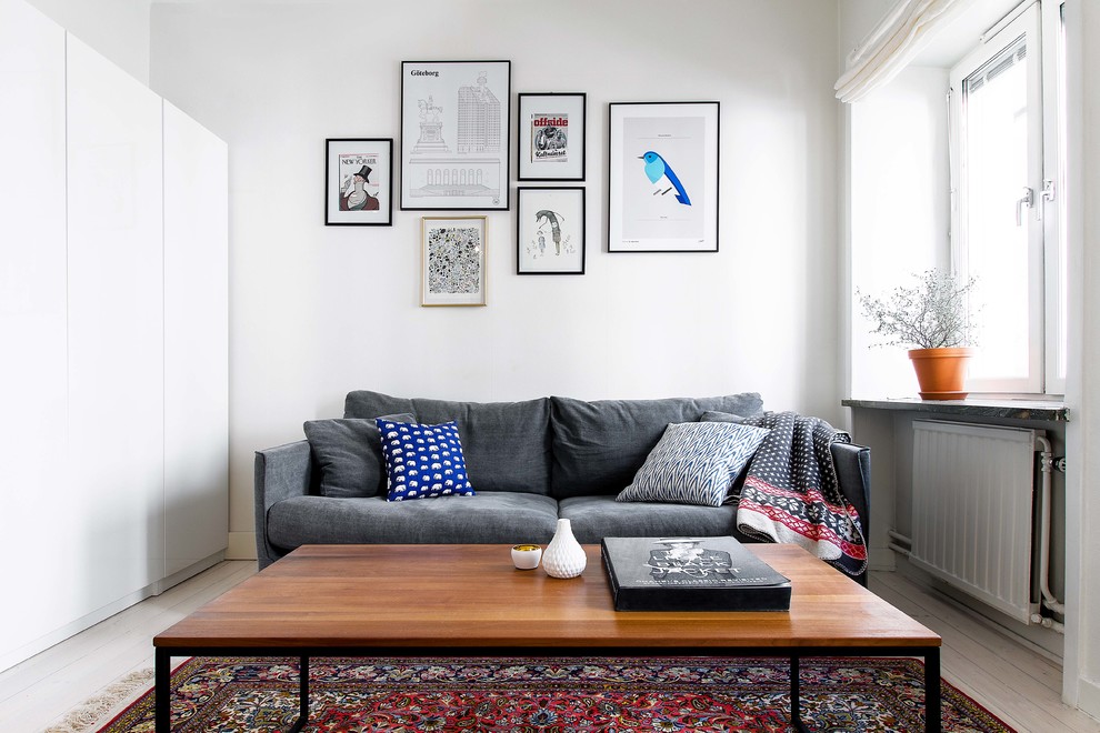 Abgetrenntes Skandinavisches Wohnzimmer ohne Kamin mit weißer Wandfarbe und hellem Holzboden in Stockholm