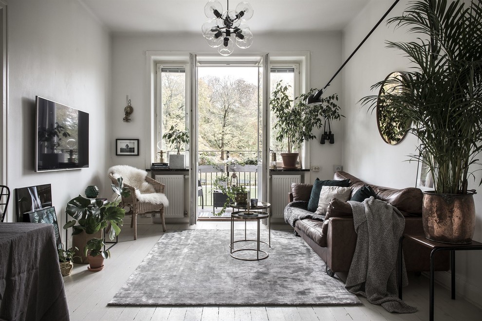 Esempio di un soggiorno boho chic chiuso con pareti beige, pavimento in legno verniciato, TV a parete e pavimento bianco