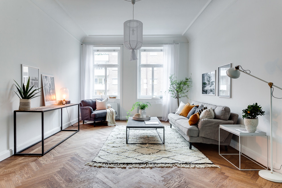 Mittelgroßes, Repräsentatives, Fernseherloses Skandinavisches Wohnzimmer ohne Kamin mit weißer Wandfarbe und braunem Holzboden in Stockholm