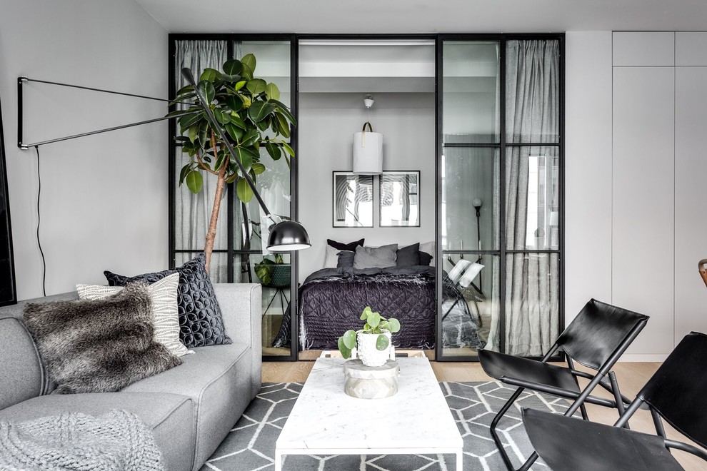 Mittelgroßes, Offenes Skandinavisches Wohnzimmer mit grauer Wandfarbe und hellem Holzboden in Stockholm