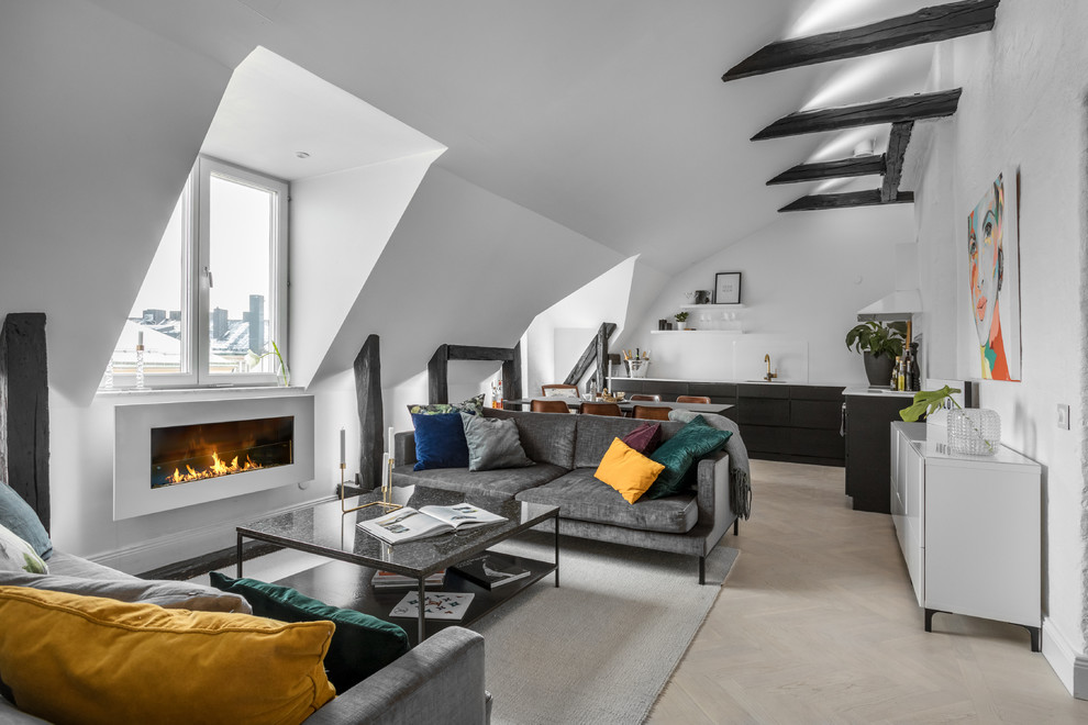 Mittelgroßes, Offenes Nordisches Wohnzimmer mit weißer Wandfarbe, hellem Holzboden, Gaskamin und beigem Boden in Stockholm