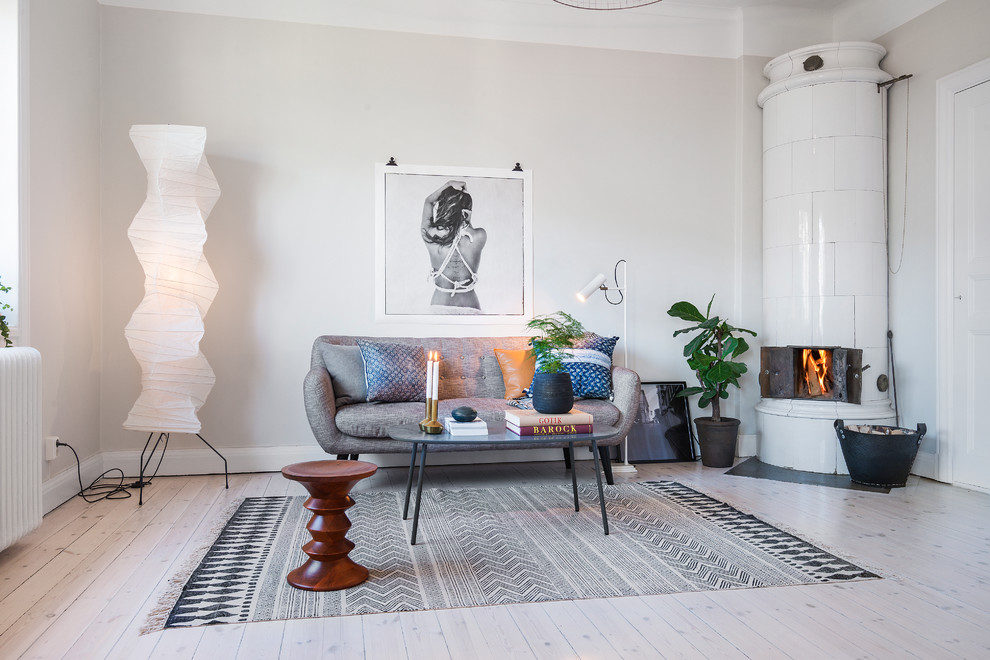 Living room - large scandinavian formal and open concept light wood floor living room idea in Stockholm with beige walls, a wood stove and no tv