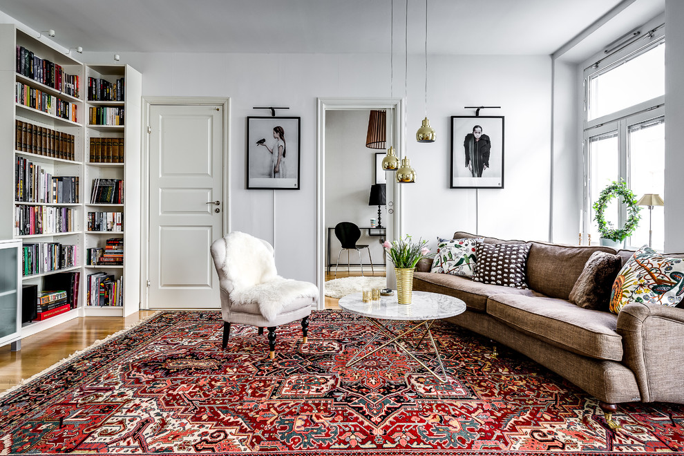 Идея дизайна: изолированная гостиная комната среднего размера в скандинавском стиле с с книжными шкафами и полками, белыми стенами, паркетным полом среднего тона и коричневым полом без камина