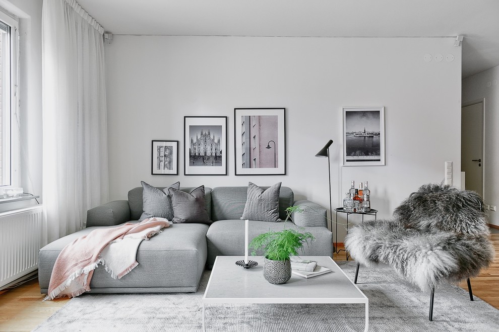 Свежая идея для дизайна: изолированная гостиная комната среднего размера в скандинавском стиле с белыми стенами и паркетным полом среднего тона - отличное фото интерьера