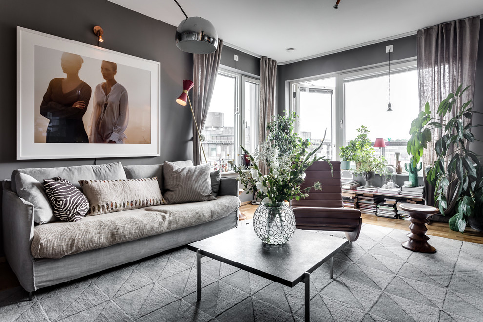 Großes, Repräsentatives, Offenes Stilmix Wohnzimmer mit grauer Wandfarbe und braunem Holzboden in Stockholm