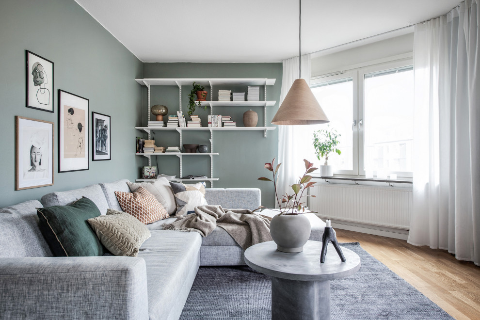 Immagine di un soggiorno scandinavo con pareti verdi, pavimento in legno massello medio e pavimento marrone