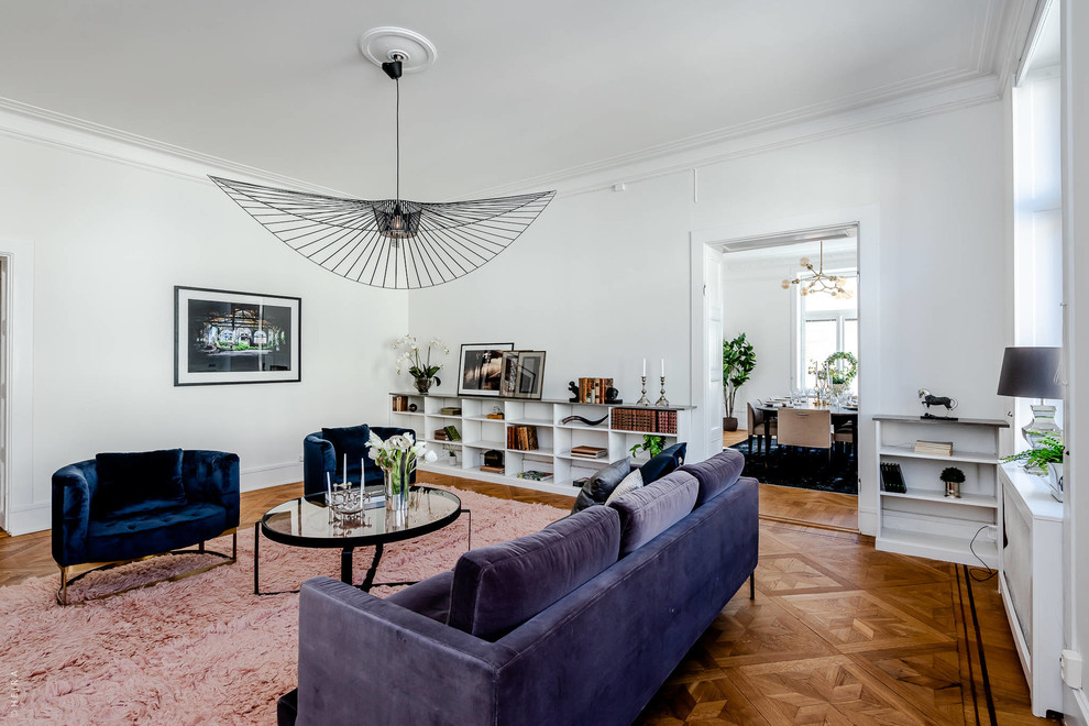 This is an example of a medium sized scandi enclosed living room in Stockholm with white walls, medium hardwood flooring, brown floors, no fireplace and no tv.