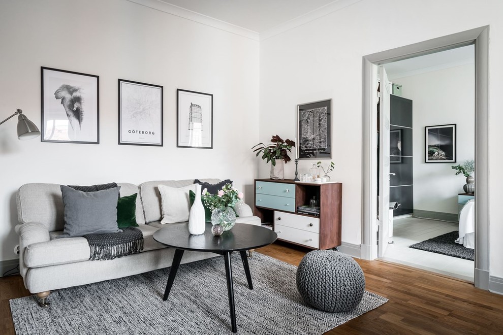Foto på ett mellanstort minimalistiskt separat vardagsrum, med vita väggar och brunt golv