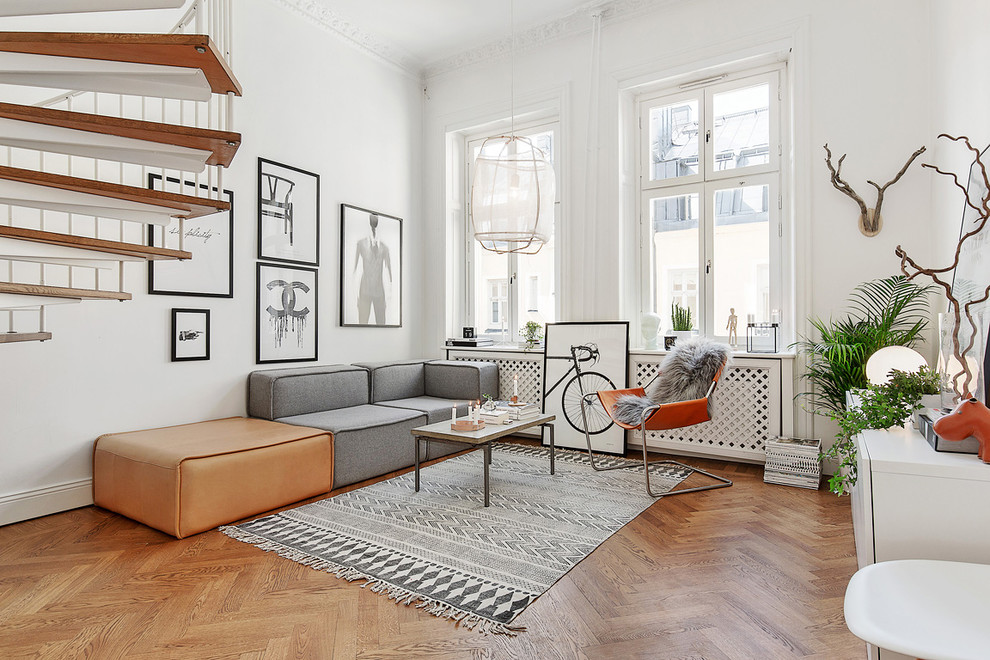 Large scandi formal open plan living room in Stockholm with white walls, medium hardwood flooring, no fireplace and no tv.