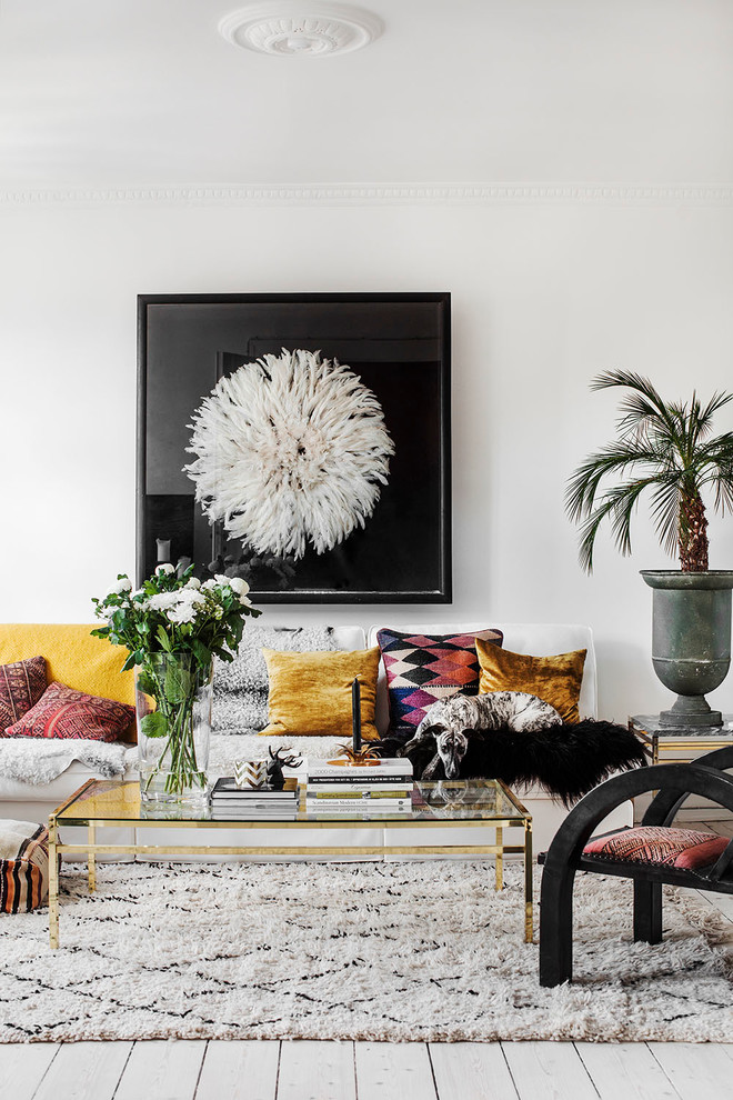 Photo of a large world-inspired formal enclosed living room in Stockholm with white walls, light hardwood flooring, no fireplace and no tv.