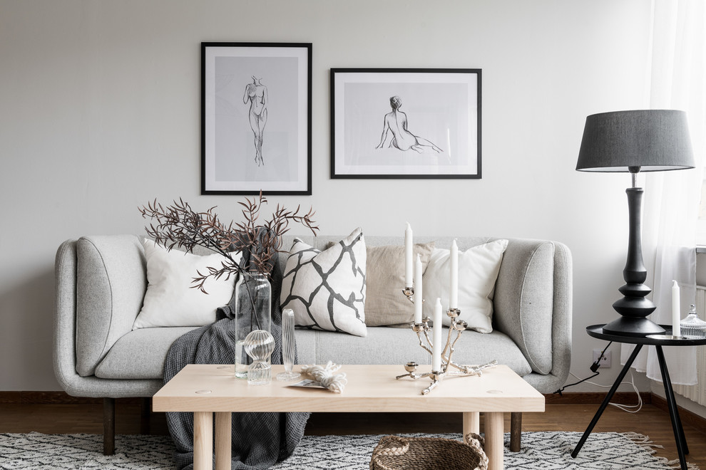 Aménagement d'un petit salon scandinave ouvert avec un mur blanc et un sol en bois brun.