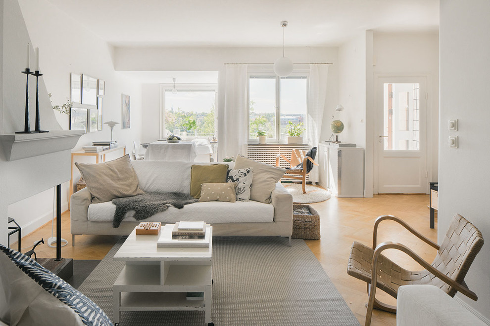 Esempio di un grande soggiorno scandinavo aperto con sala formale, pareti bianche, parquet chiaro e nessuna TV