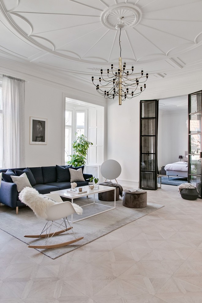 Cette image montre un salon nordique avec une salle de réception, un mur blanc, parquet clair et un sol beige.