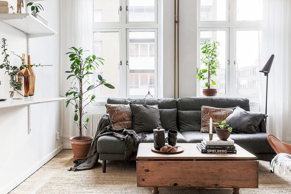 Mid-sized danish enclosed light wood floor and beige floor living room photo in Malmo with white walls