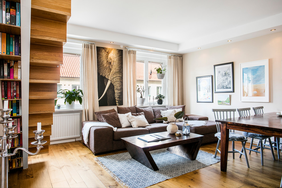 Idée de décoration pour un salon tradition de taille moyenne et ouvert avec un mur beige et un sol en bois brun.