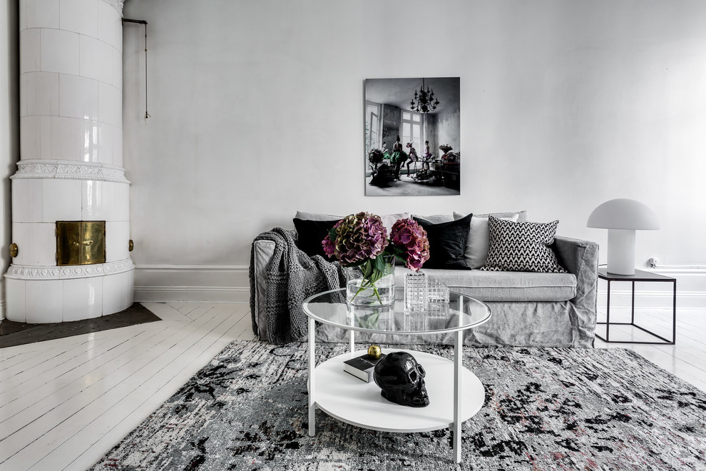 Источник вдохновения для домашнего уюта: открытая, парадная гостиная комната среднего размера в скандинавском стиле с серыми стенами, фасадом камина из плитки, деревянным полом и печью-буржуйкой