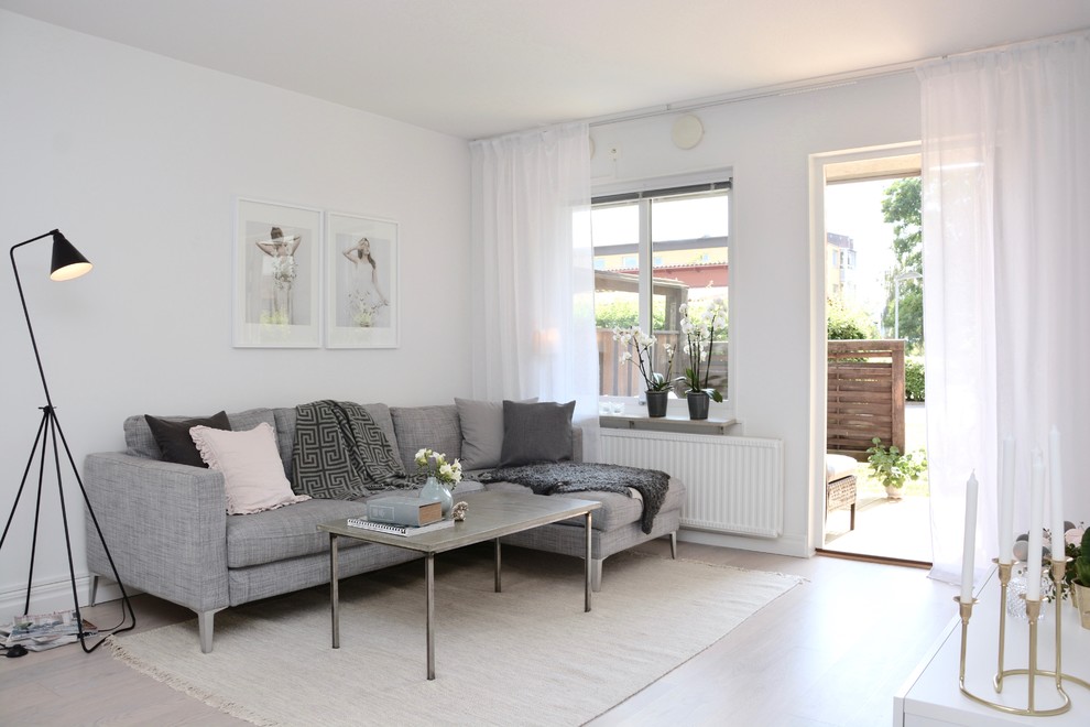 Scandi living room in Other with white walls, light hardwood flooring, no fireplace and no tv.