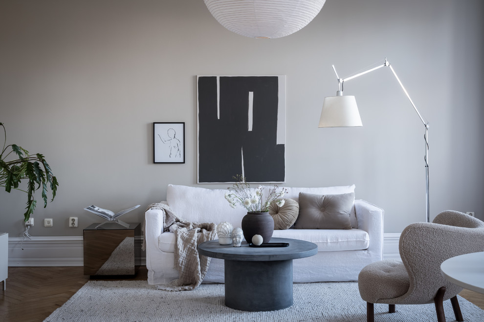 Idéer för att renovera ett minimalistiskt vardagsrum, med grå väggar, mellanmörkt trägolv och brunt golv