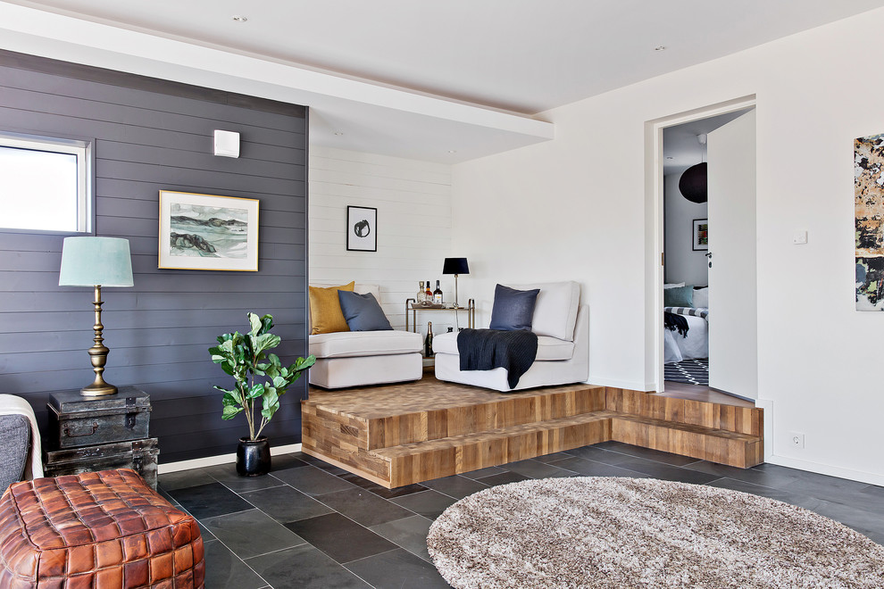 На фото: открытая гостиная комната в морском стиле с разноцветными стенами и черным полом без камина, телевизора