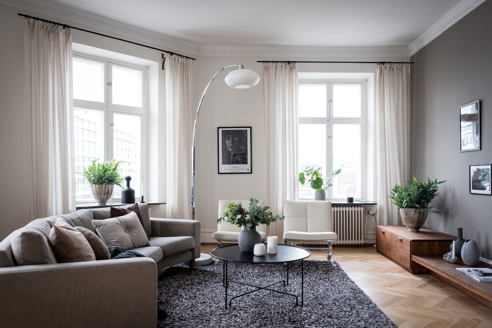 Foto på ett minimalistiskt separat vardagsrum, med vita väggar, ljust trägolv och beiget golv