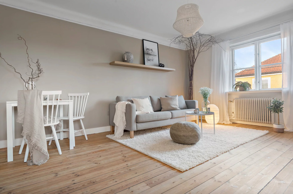 Diseño de salón abierto nórdico pequeño con paredes beige, suelo de madera clara y suelo beige