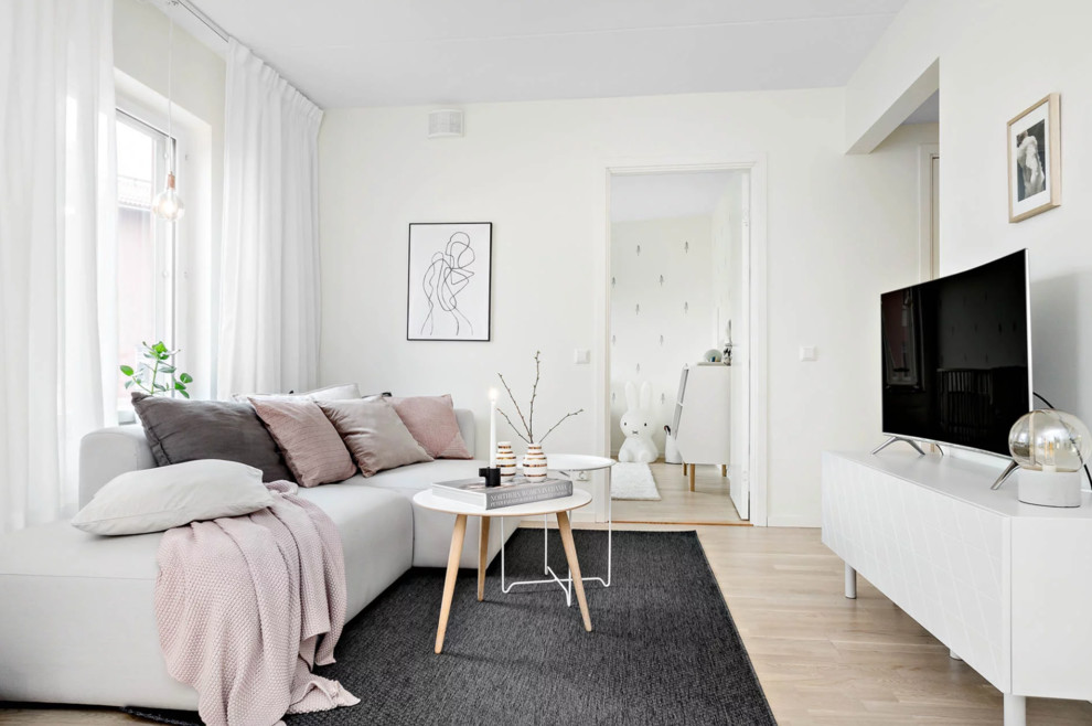 Photo of a medium sized scandi open plan living room in Stockholm with white walls, light hardwood flooring, a freestanding tv and beige floors.
