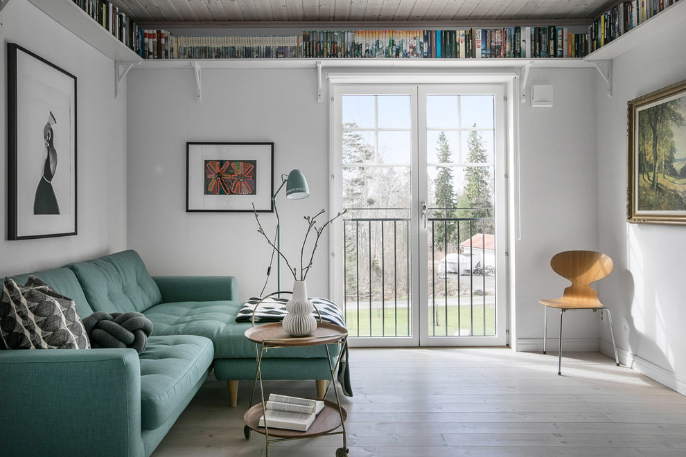 Scandinavian living room in Stockholm with white walls, medium hardwood flooring and brown floors.