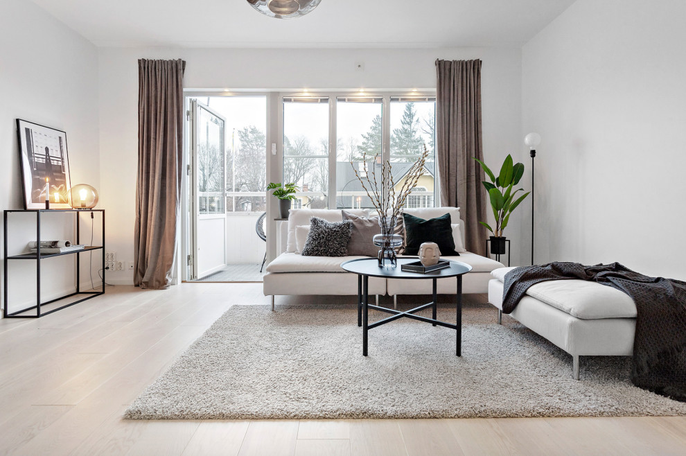 Immagine di un soggiorno nordico di medie dimensioni con pareti bianche, parquet chiaro, nessuna TV e pavimento beige