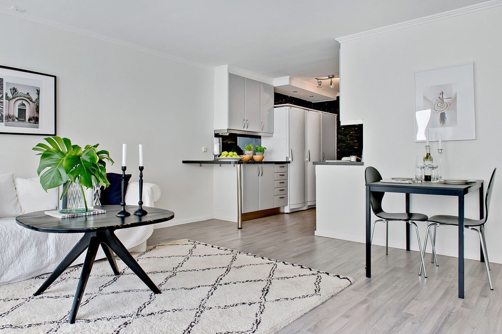 На фото: маленькая открытая гостиная комната в скандинавском стиле с светлым паркетным полом и белыми стенами без камина, телевизора для на участке и в саду с