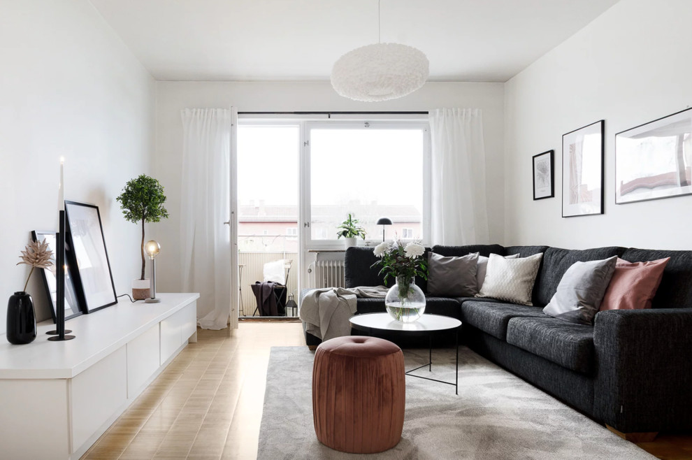 Klassisches Wohnzimmer mit weißer Wandfarbe, hellem Holzboden und beigem Boden in Stockholm