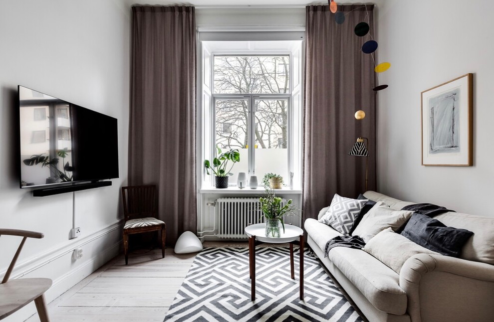 Foto på ett skandinaviskt vardagsrum, med vita väggar, ljust trägolv, beiget golv och en väggmonterad TV