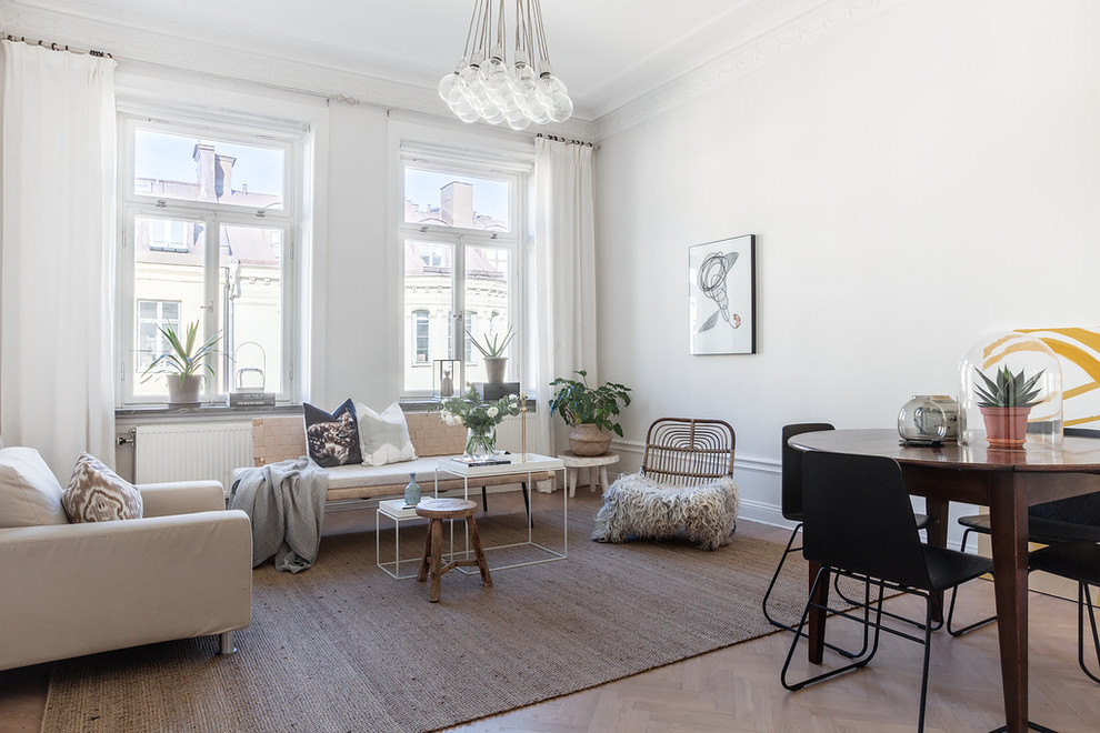 Scandi formal open plan living room in Stockholm with white walls, light hardwood flooring and no tv.