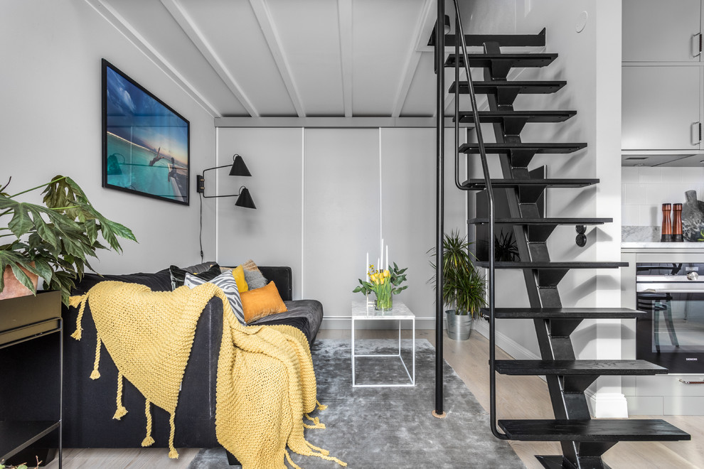 Idéer för nordiska loftrum, med ljust trägolv, beiget golv, grå väggar och en väggmonterad TV