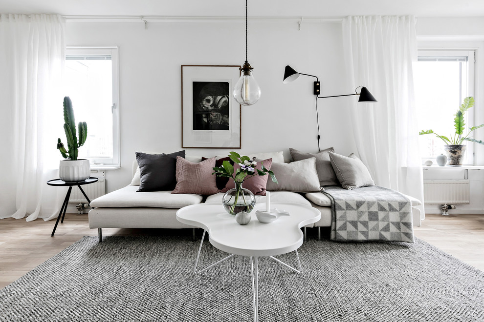 Diseño de salón cerrado escandinavo de tamaño medio con paredes blancas, suelo de madera clara y suelo beige