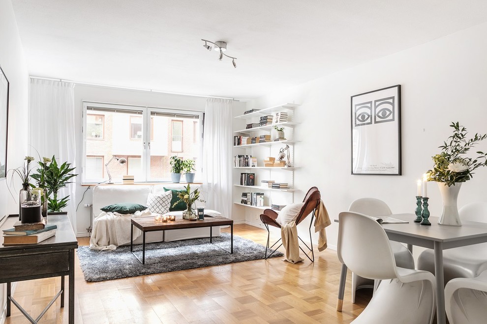 Immagine di un soggiorno scandinavo aperto con pareti bianche, pavimento in legno massello medio e pavimento marrone