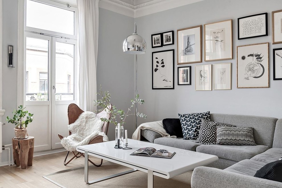 Стильный дизайн: парадная, изолированная гостиная комната в скандинавском стиле с серыми стенами, светлым паркетным полом и бежевым полом - последний тренд