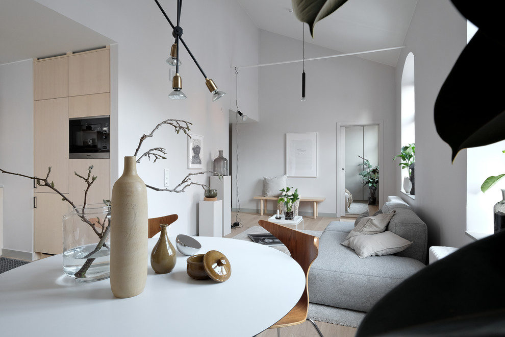 Large scandinavian formal open plan living room in Stockholm with grey walls, light hardwood flooring, no fireplace and no tv.